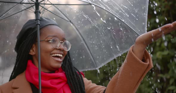 Black Girl with an Umbrella in the Middle of the Autumn Street