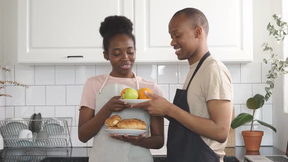 Beautiful Young Man Stands with Fruits Plate, They Have Conversation and Smile