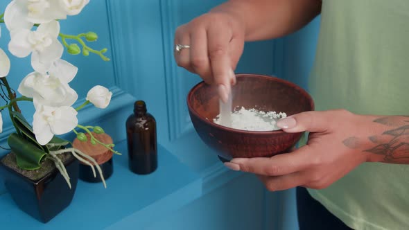 Woman Stirring Blend for Cosmetic Facial Mask in Clay Bowl Indoors