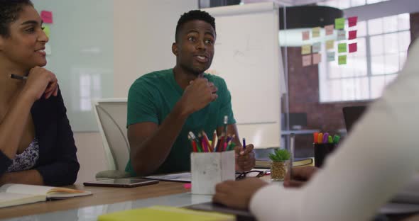 Mixed race business colleagues sitting having a discussion in meeting room