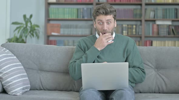 Young Man Getting Shocked While Working on Laptop