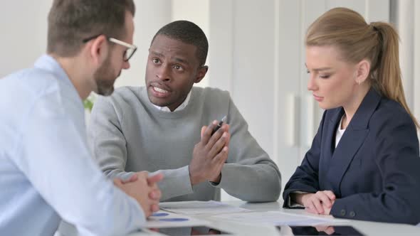 Young African Businessman Explaining Documents to Colleagues