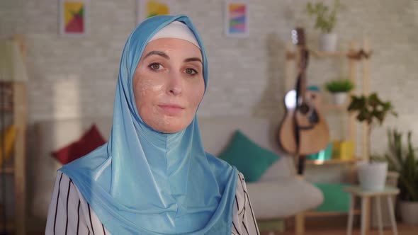 Smiling Muslim Woman in Hijab with a Burn Scar on Her Face Looking at the Camera