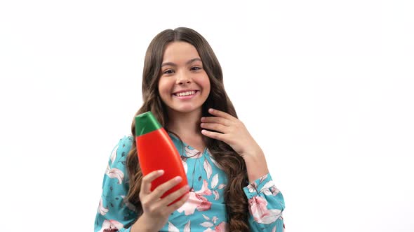 Happy Child Girl with Curly Hair Presenting Cosmetic Product for Teen Showing Thumb Up Haircare