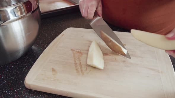 Preparing potato wedges on baking sheet in oven.