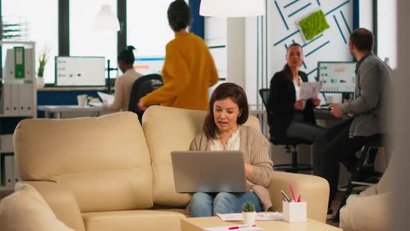 Manager Woman Sitting on Couch Holding Laptop and Talking on Video Call