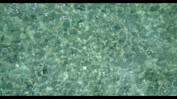 Aerial above sky of idyllic tourist beach break by clear ocean and white sandy background of a daytr