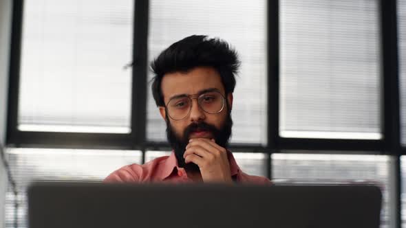 Closeup Front View of Bearded Young Business Man Wearing Glasses Having Work Problem at Laptop