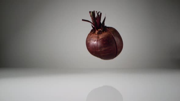 Cut beet falling on water surface. Slow Motion.