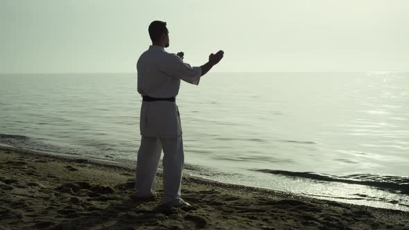 Calm Sportsman Training Karate Watching Sunset on Beach