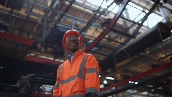 Cheerful Professional Looking Camera at Modern Huge Manufacturing Warehouse