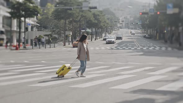 Girl Walking on Crosswalk with Luggage