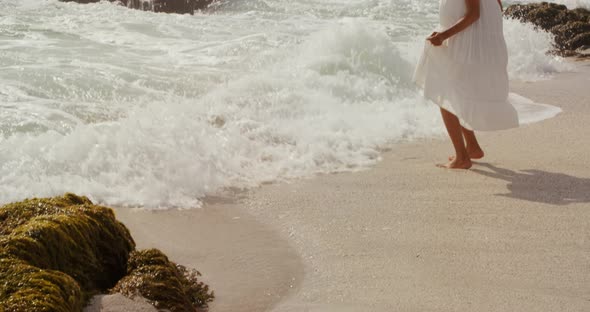 Side view of African american woman playing with sea water on the beach 4k