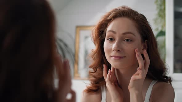 Redhead caucasian woman in the bathroom checking face condition. Shot with RED helium camera in 8K.