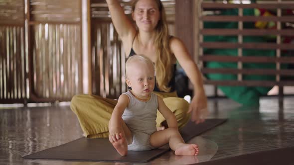 Mother With An Infant Sitting In A Mat During Yoga Class Sessions In Koh Phangan Thailand