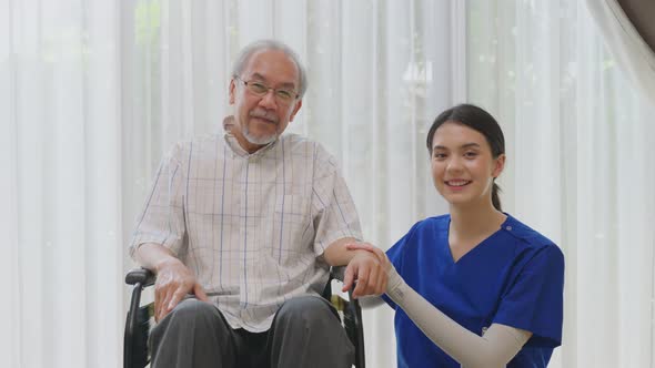 Portrait of Happy Asian disabled Senior Elderly male on wheelchair enjoy stay home nursing care.