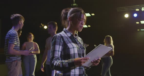 Students preparing before a high school performance in an empty school theater 