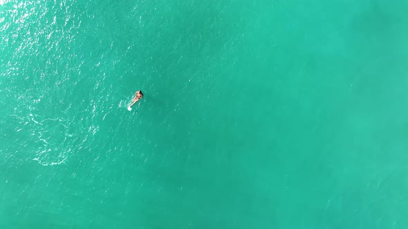 A man swims in the sea aerial view 4K