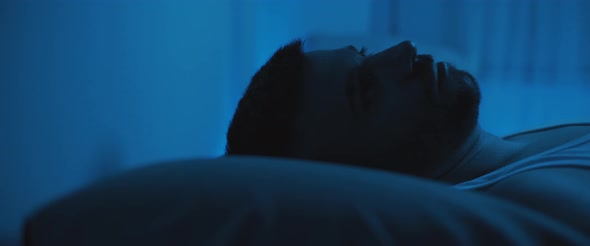 Close up of a soldier lying on bed, staring at the ceiling, dealing with post trauma.