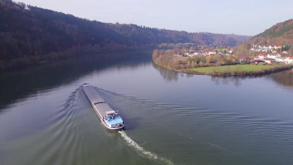 Cargo Pusher Boat on a River Transporting Cargo and Goods Along a River Bend