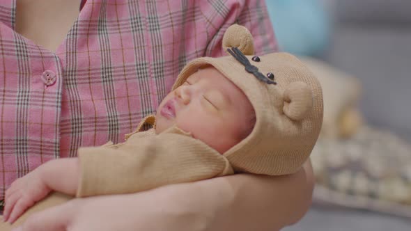 Adorable sleeping newborn baby relax in mother arm safety and comfortable