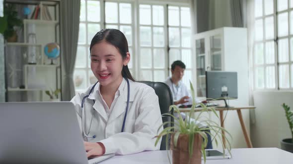 Young Asian Woman Doctor Is Using Laptop In Workplace. Medical Concept