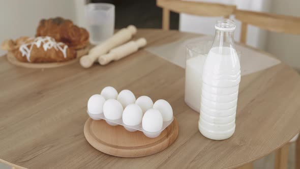 Milk in a Plastic Bottle Eggs and Flour Lie on a Wooden Table
