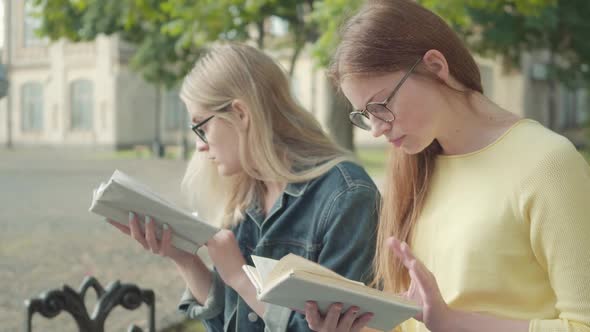 Close-up Side View of Focused Girls in Eyeglasses Hiding Behind Books As Handsome Athletic Sportsman