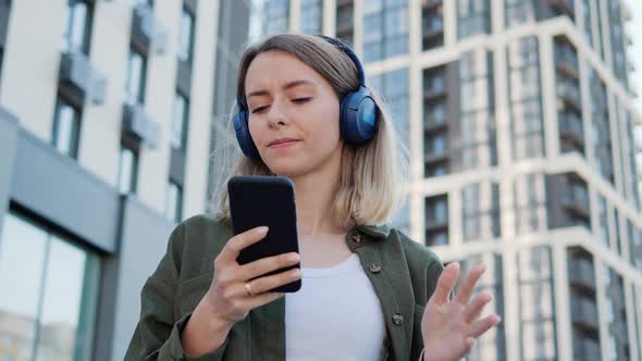 Smiling Young Girl Dancing in Headphones at the City Street Enjoying Free Time