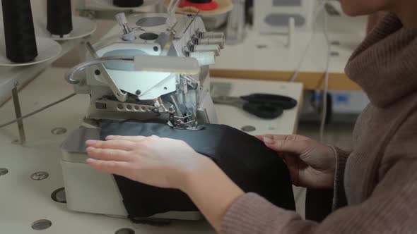 Sewing workshop. Processing the edge of the product on the overlock. Zigzag machine stitch
