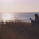 Young caucasian woman reading a book at the beach - VideoHive Item for Sale