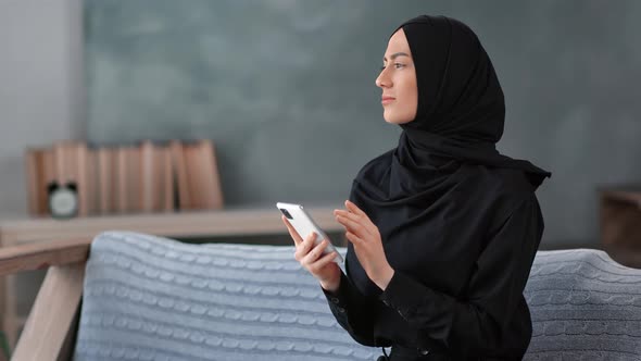 Pleasant Muslim Lady in Hijab Chatting Surfing Internet Use Smartphone