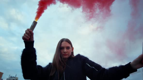 Woman Looking at Camera Through Smoke. Girl Using Smoke Bombs at Protest