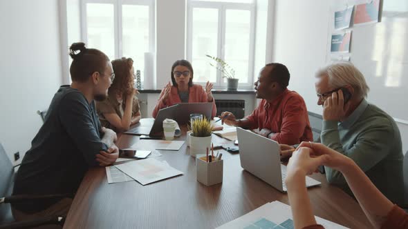 Female Manager Talking to Mixed-Aged Business Team at Meeting