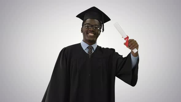 Happy African American Male Student in Graduation Robe Walking with Diploma and Talking To Camera on