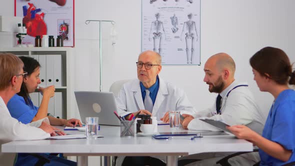 Senior Specialist Man Doctor Explaining Treatment to Colleagues