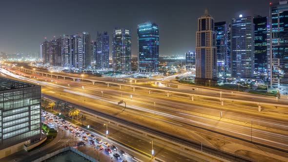 Aerial View of Jumeirah Lakes Towers Skyscrapers Night Timelapse with Traffic on Sheikh Zayed Road