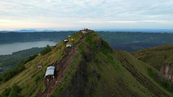 aerial over a green ridge at Mount Batur Volcano crater during sunrise in Bali Indonesia