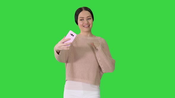 Emotional Young Female Finishing Video Call on Her Phone While Walking on a Green Screen, Chroma Key