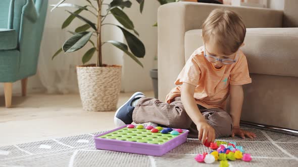 Child Playing with Educational Game Toy Sitting on the Floor at Home