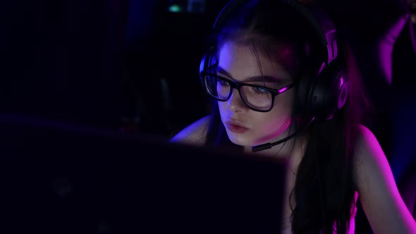 Young Woman in Headphones Playing an Online Game in Gaming Club