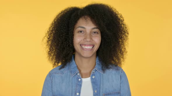 African Woman Smiling at Camera, Yellow Background 