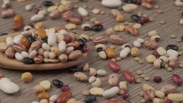 Dry legumes, mixed beans, chickpeas, lentils, soup on wooden spoon, Mediterranean healthy diet nutri