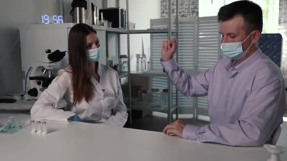 Female Doctor with Medical Mask and Gloves Prepares Prefilled Syringe for Injection By Removing Cap