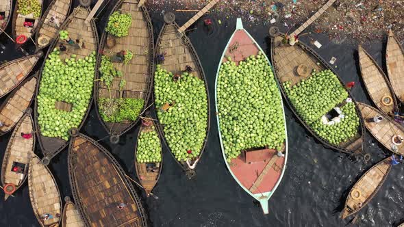 Aerial view of workers exchanging watermelons on boats along the Buriganga River.