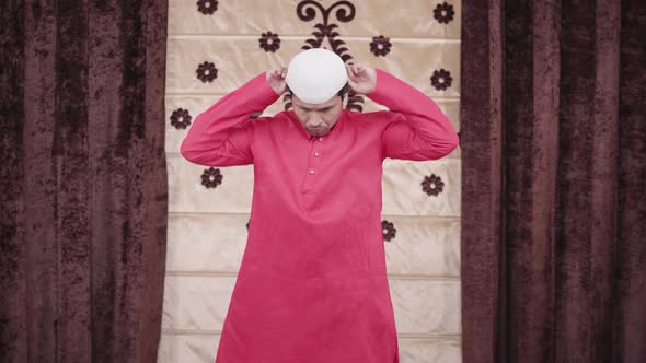 Muslim man adjusting his cap