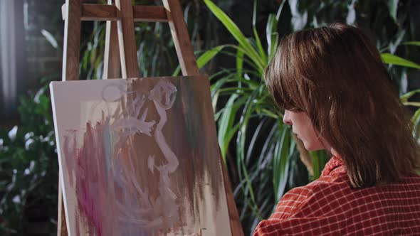 Young Woman Drawing an Abstract Painting on a Canvas