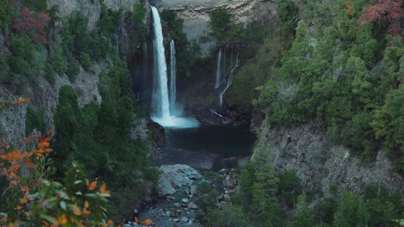 Establishing shot of a cascade with rocks and vegetation around in a national park of Chile