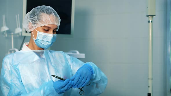 A Nurse in the Operating Room Takes a Medical Clip