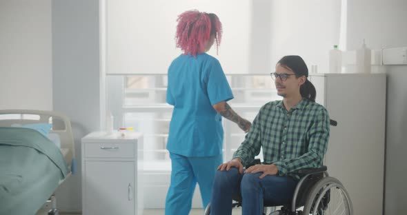 Nurse with Patient Sitting in Wheelchair in Hospital